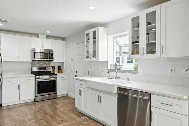 a kitchen with granite countertop a sink stainless steel appliances and cabinets