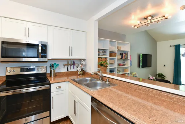a kitchen with stainless steel appliances a stove sink microwave and cabinets