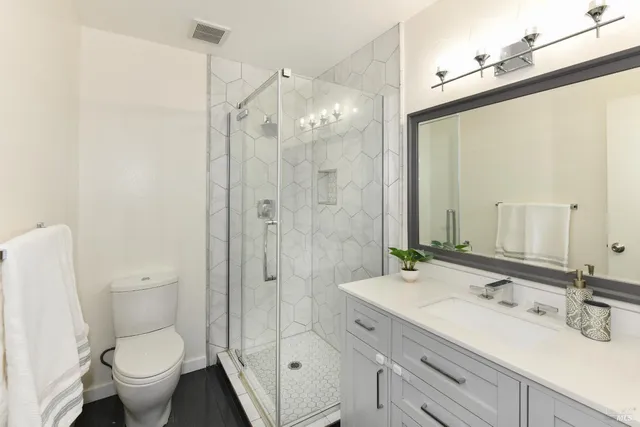 a bathroom with a shower sink mirror and toilet