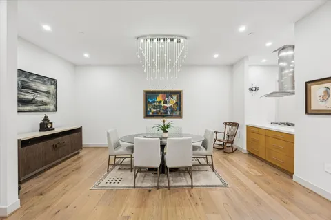 a living room with furniture a dining table and a potted plant