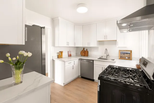 a kitchen with a white stove top oven and white cabinets