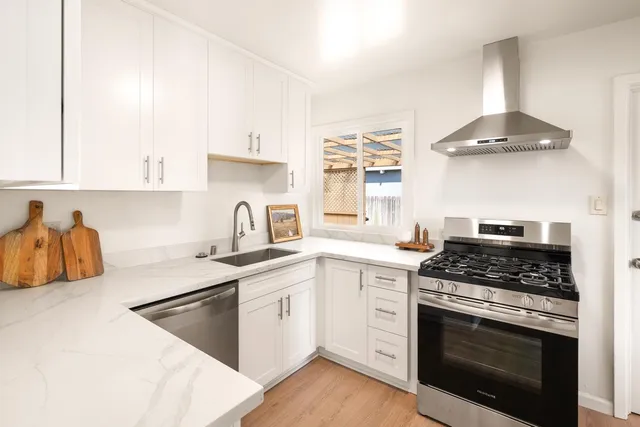 a kitchen with stainless steel appliances granite countertop a sink stove and cabinets