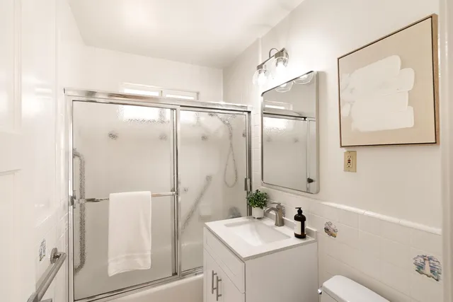 a bathroom with a sink and mirror with toilet