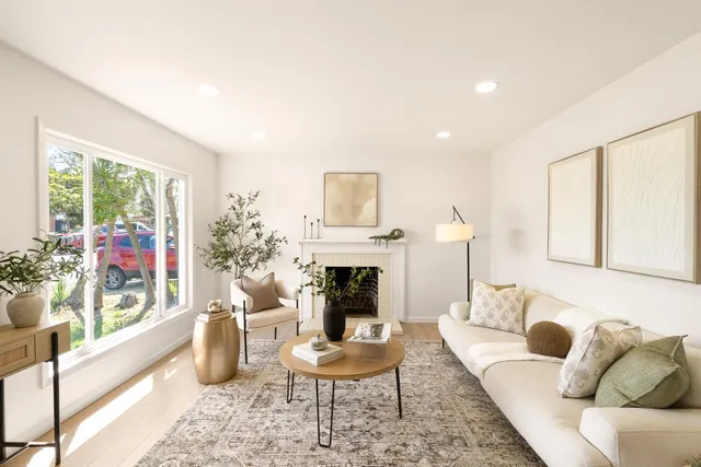 a living room with furniture a fireplace and a large window