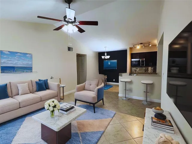 a living room with furniture and a view of kitchen