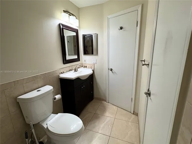 a bathroom with a granite countertop toilet sink and mirror