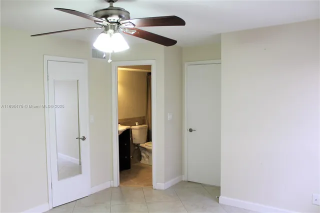 a view of a bathroom with a shower and a ceiling fan