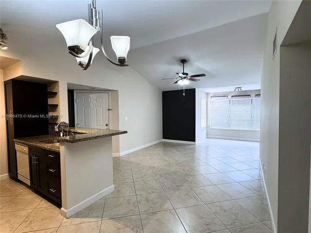 a kitchen with kitchen island stainless steel appliances a stove and a chandelier