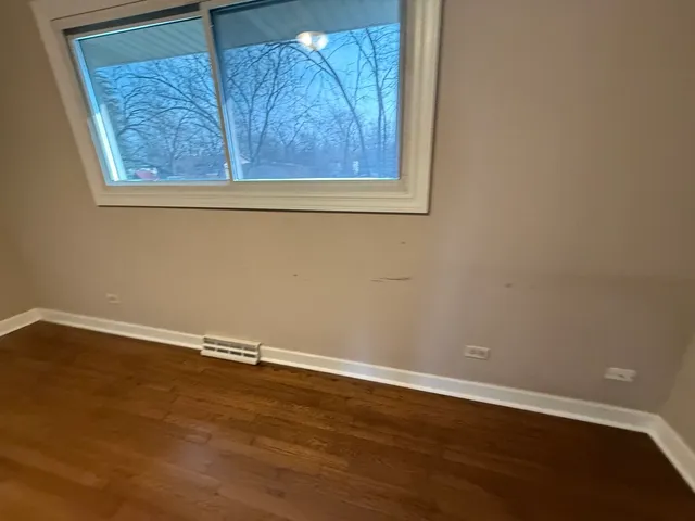 a view of a small space with wooden floor and a window