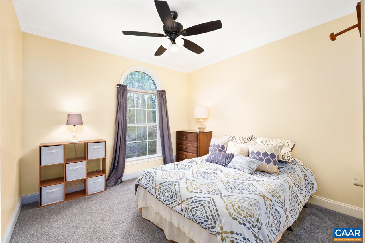 323 Buffalo Run Road Stanardsville, VA 22973 - Photo 26 of 37 a bedroom with a bed and a chandelier