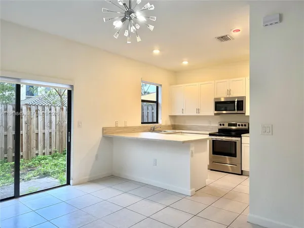 a large kitchen with stainless steel appliances granite countertop a stove and a sink