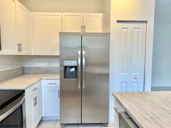a kitchen with a refrigerator and cabinets
