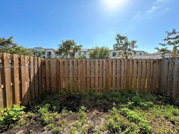 a view of a garden with wooden fence