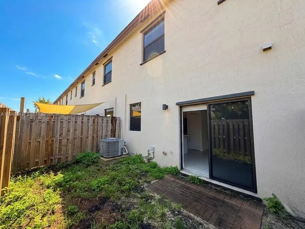 a view of backyard with potted plants and wooden fence