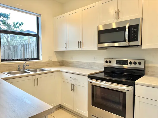 a kitchen with stainless steel appliances granite countertop a sink and a microwave