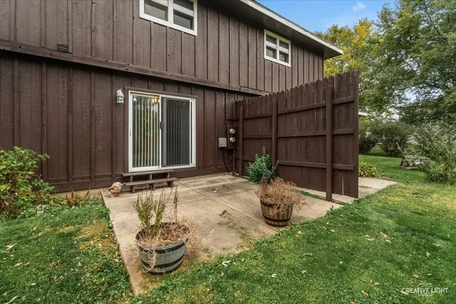 a backyard of a house with wooden fence and large trees