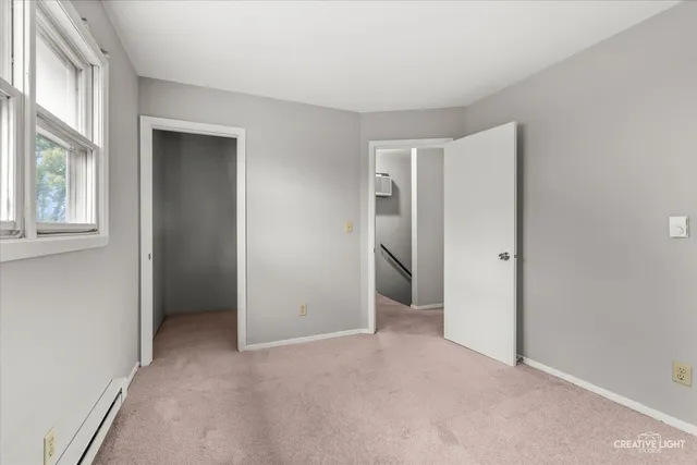 an empty room with windows and closet