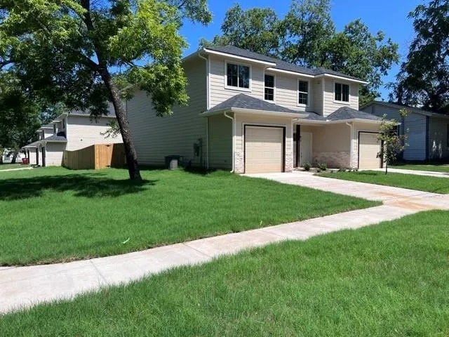 a front view of a house with a yard and trees