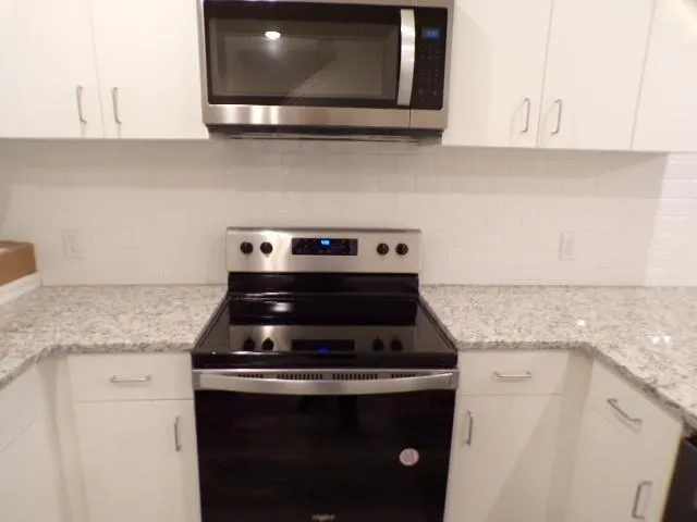 a stove top oven sitting inside of a kitchen