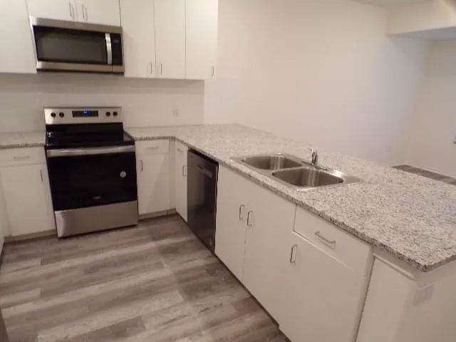 a kitchen with granite countertop a sink and a stove top oven