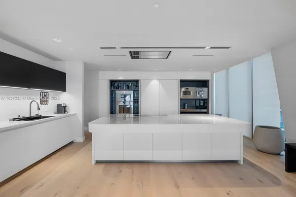 a large bed sitting in a kitchen and a flat screen tv