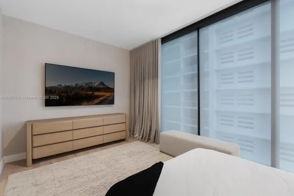 a bedroom with a bed and a television