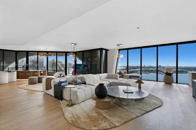 a living room with couches and a large window with balcony view