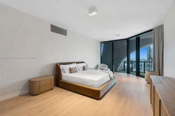 a bedroom with a bed and a large window