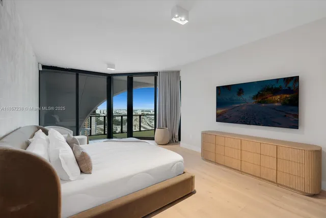 a bedroom with a large bed and a flat screen tv