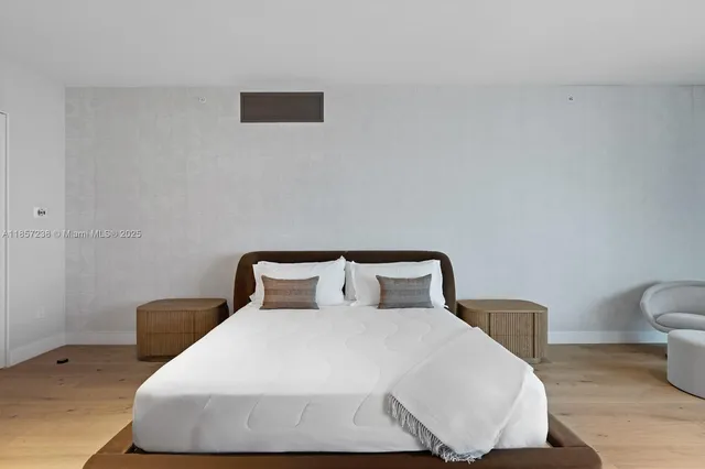 a bedroom with a bed and a lamp with wooden floor