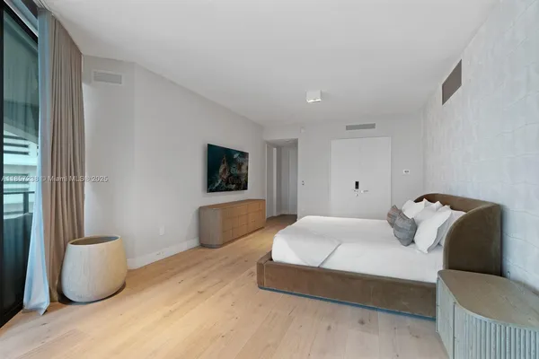 a bedroom with a bed and a flat screen tv