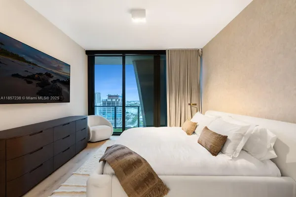 a bedroom with a bed and flat screen tv