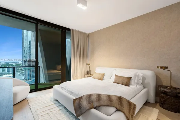 a bedroom with a bed and a large window