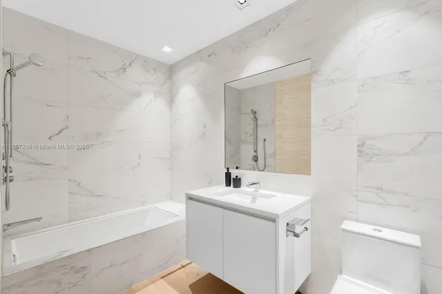 a bathroom with a sink mirror toilet and bathtub