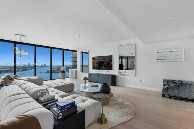 a living room with furniture a large window and a flat screen tv