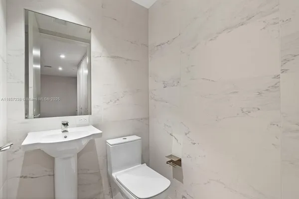 a bathroom with a sink toilet and mirror