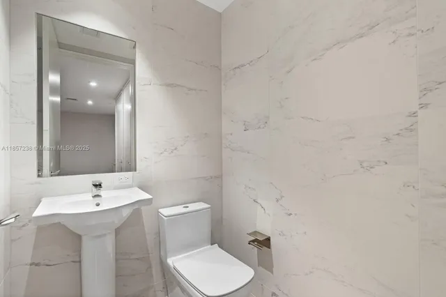 a bathroom with a sink toilet and mirror