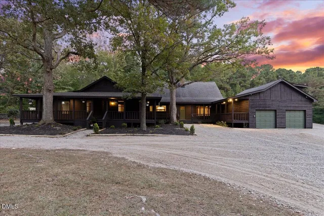 a front view of a house with a yard and tree