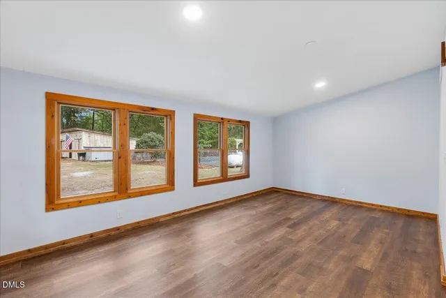 a view of an empty room with cabinet and a window