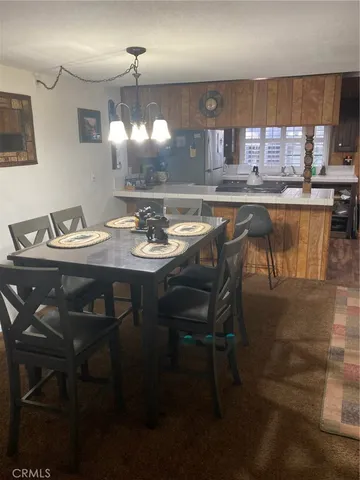 a kitchen with stainless steel appliances kitchen island granite countertop a sink a stove a dining table and chairs