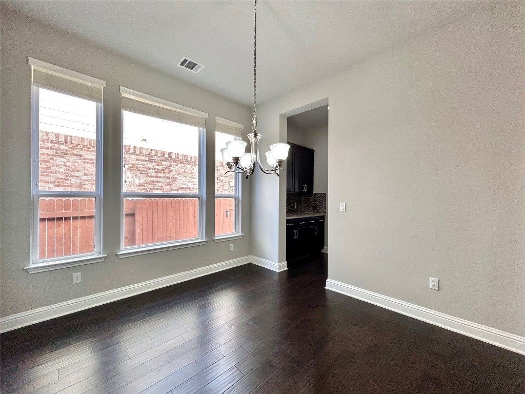 9313 Kyles Stake Road Austin, TX 78717 - Photo 12 of 40 Unfurnished dining area with a chandelier and dark wood-type flooring
