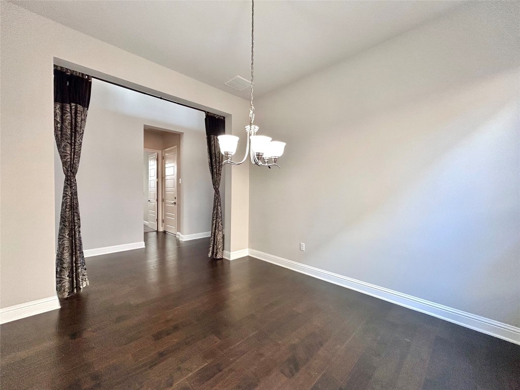 9313 Kyles Stake Road Austin, TX 78717 - Photo 13 of 40 Unfurnished dining area with dark wood finished floors and a chandelier