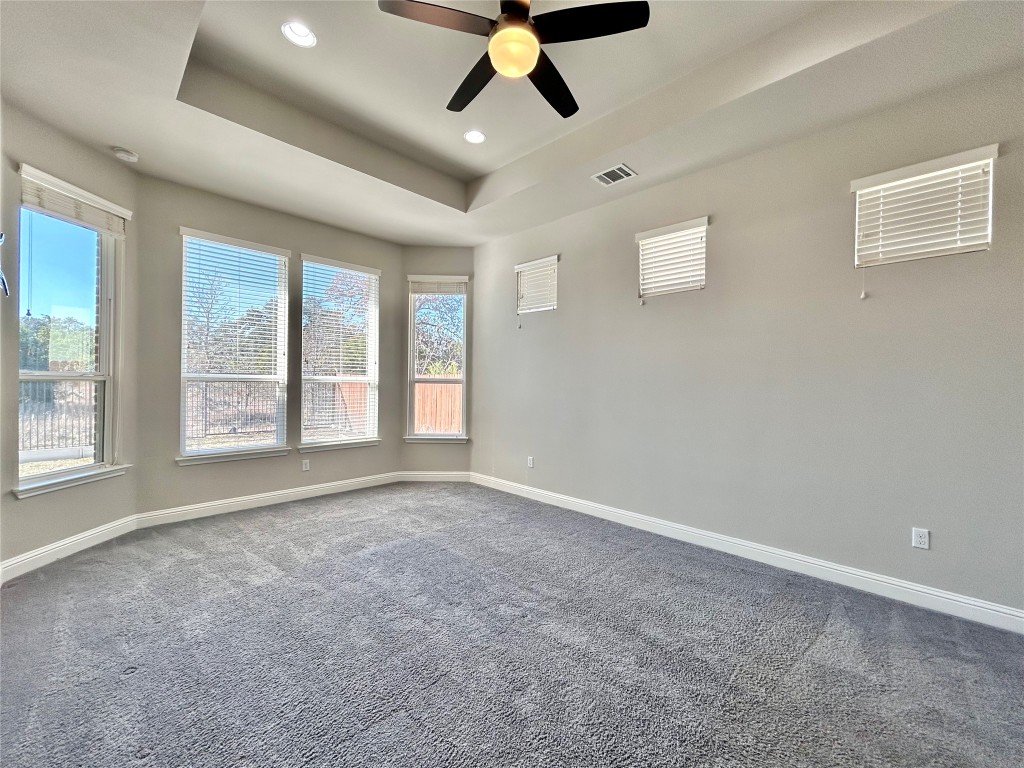 9313 Kyles Stake Road Austin, TX 78717 - Photo 16 of 40 Empty room with carpet floors, a tray ceiling, a ceiling fan, and recessed lighting