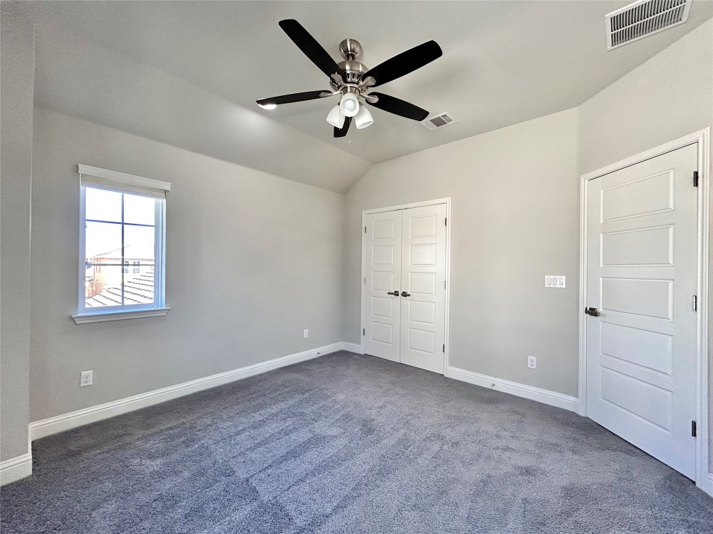 9313 Kyles Stake Road Austin, TX 78717 - Photo 30 of 40 Unfurnished bedroom featuring lofted ceiling, dark colored carpet, a ceiling fan, and a closet