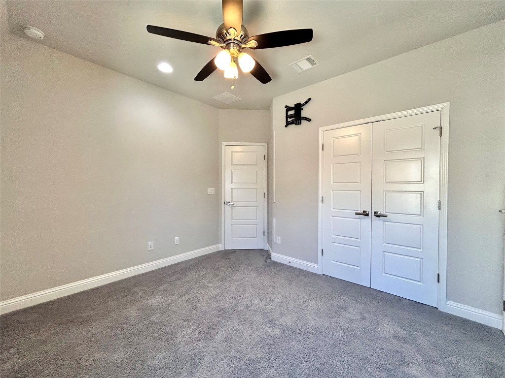9313 Kyles Stake Road Austin, TX 78717 - Photo 33 of 40 Unfurnished bedroom featuring dark colored carpet, a ceiling fan, and a closet