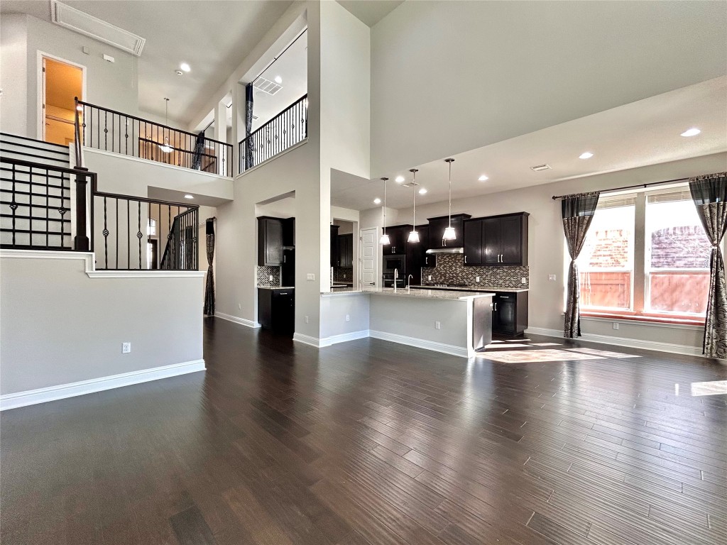 9313 Kyles Stake Road Austin, TX 78717 - Photo 4 of 40 Unfurnished living room featuring recessed lighting, dark wood finished floors, a high ceiling, and stairs