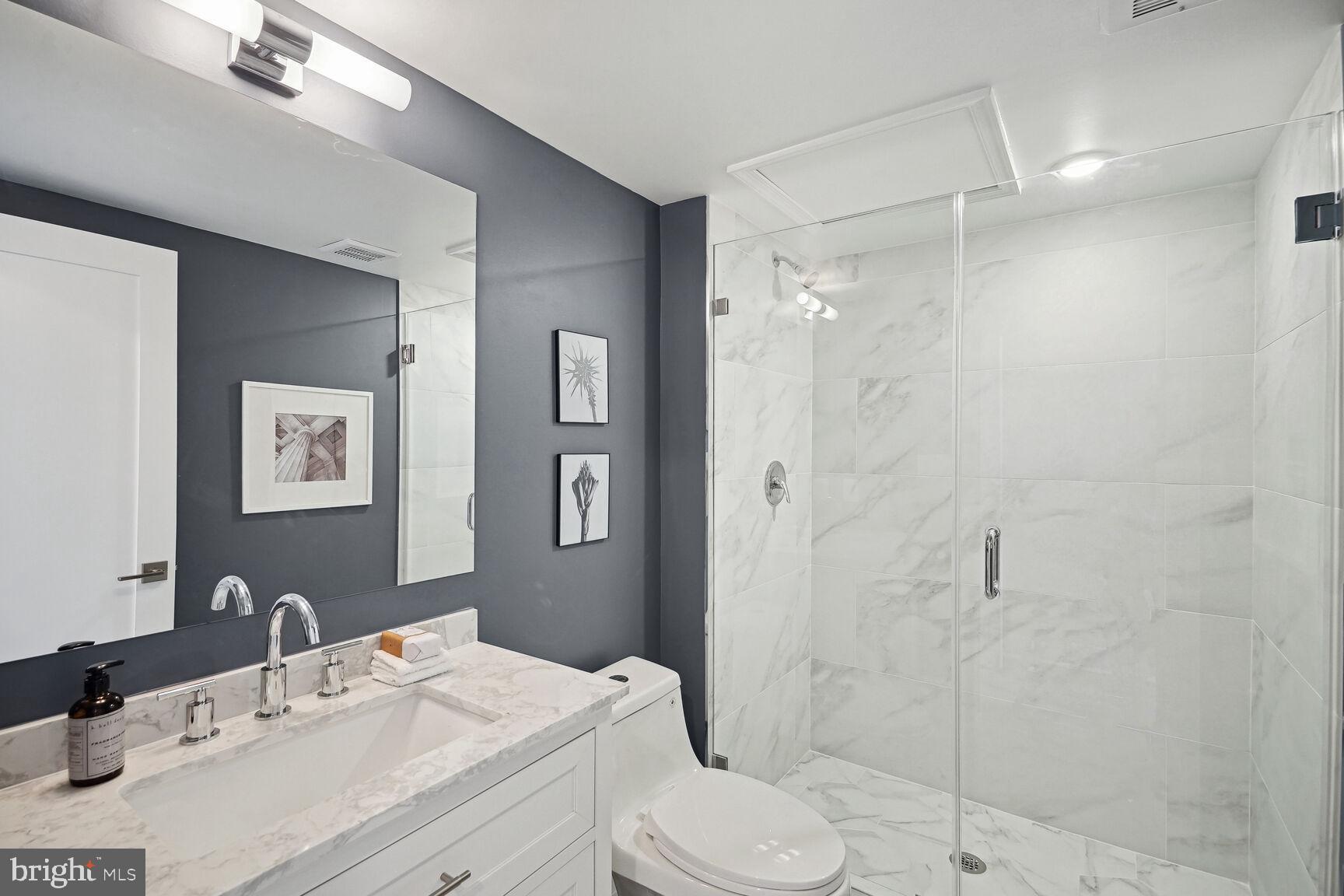 901 19th Street Northeast, Unit PH2 Washington, DC 20002 - Photo 23 of 31 a bathroom with a sink toilet vanity and shower