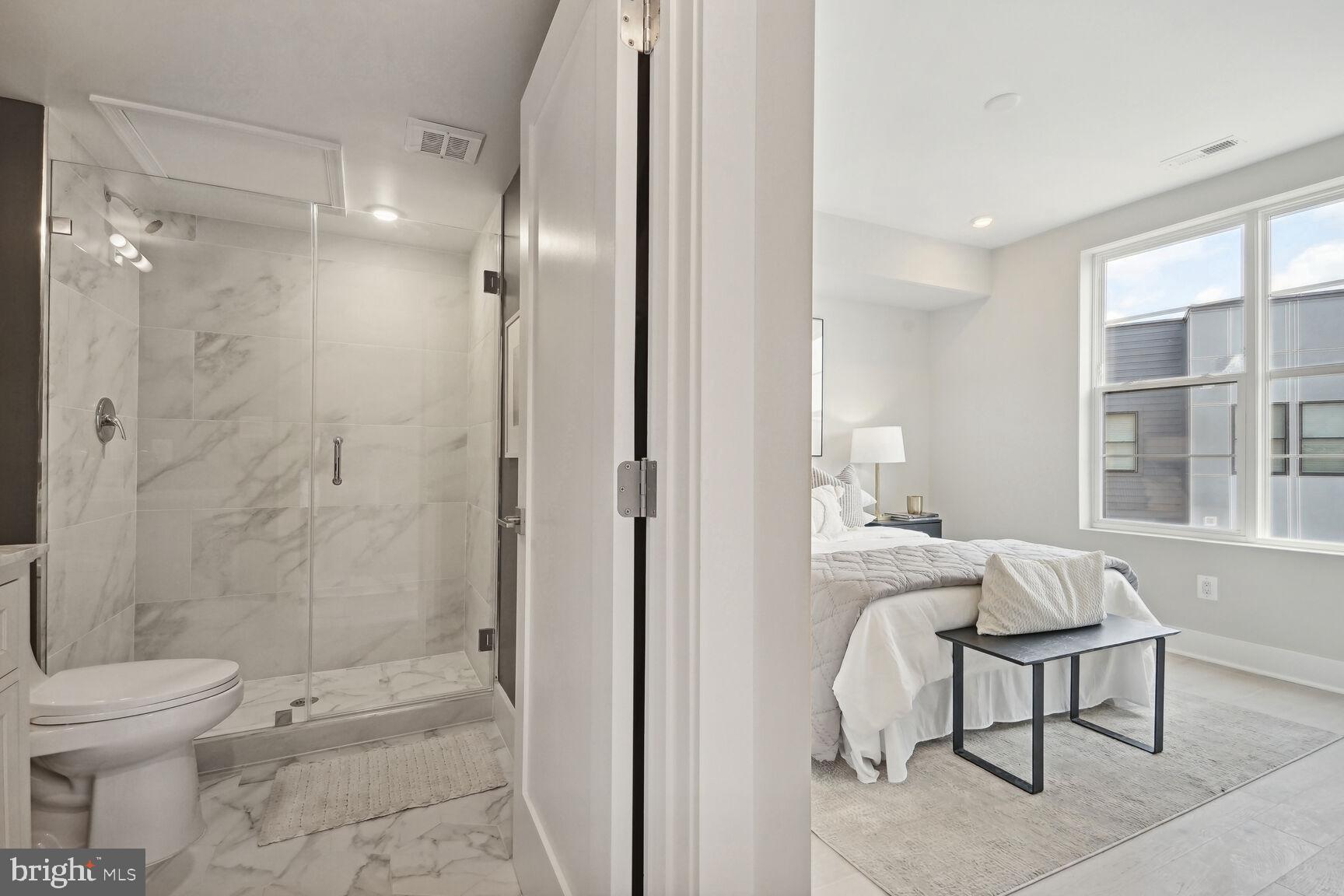901 19th Street Northeast, Unit PH2 Washington, DC 20002 - Photo 24 of 31 a spacious bathroom with a granite countertop sink toilet a mirror and a shower