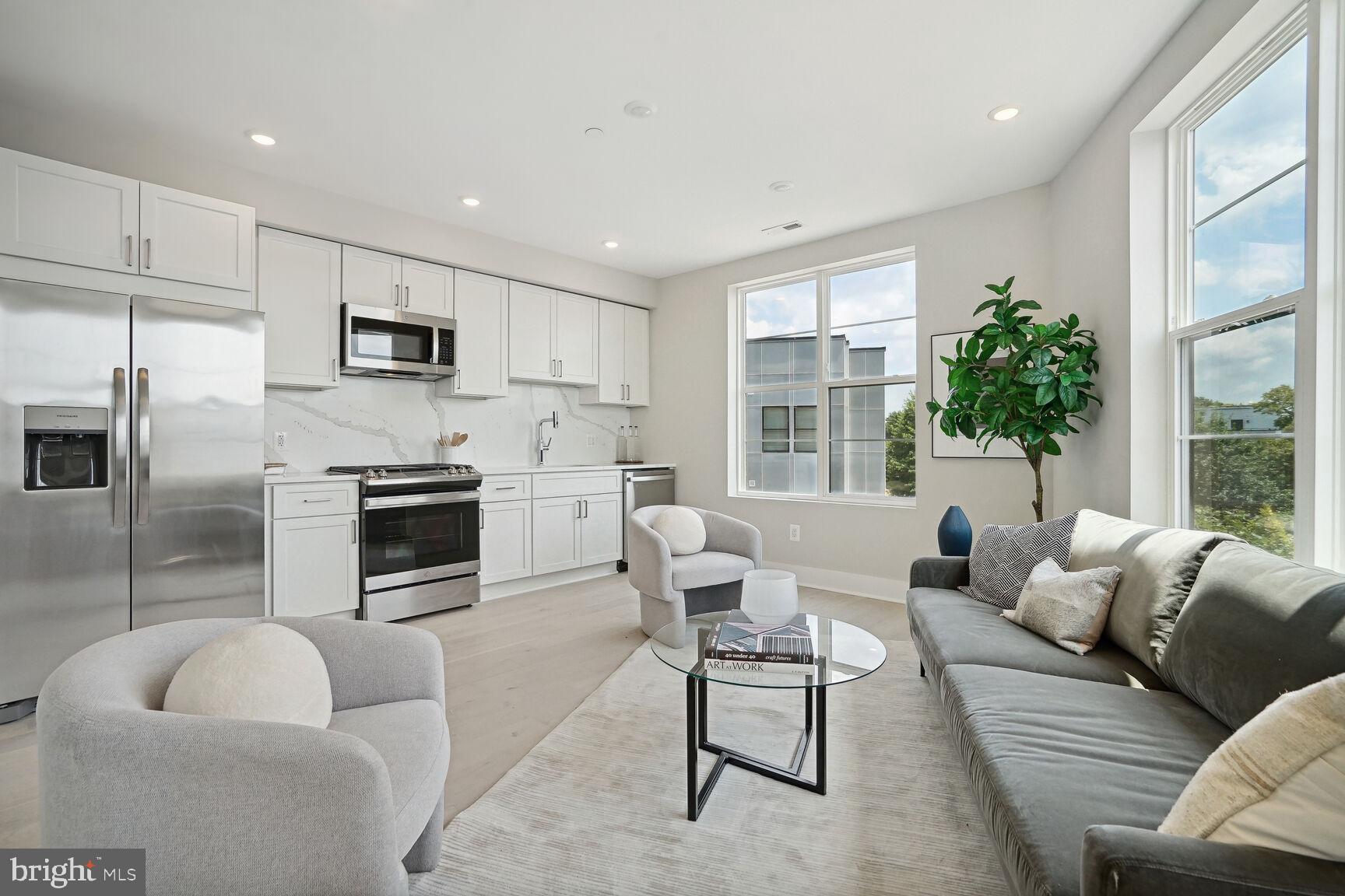 901 19th Street Northeast, Unit PH2 Washington, DC 20002 - Photo 3 of 31 a living room with furniture a fireplace a flat screen tv and windows