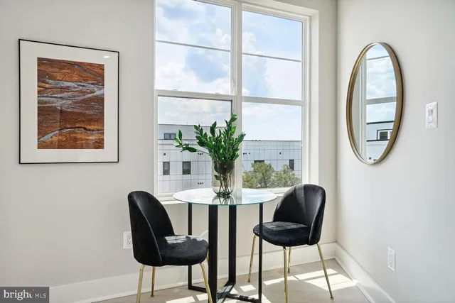 a dining room with furniture and a potted plant
